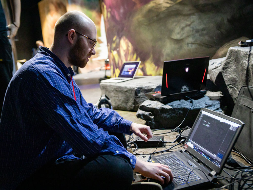 在安装博物馆展览期间，学生在一台笔记本电脑上工作