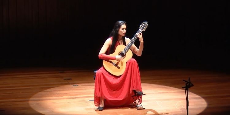 一个女人在舞台上弹吉他